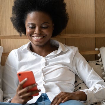 A young female researches on her phone.