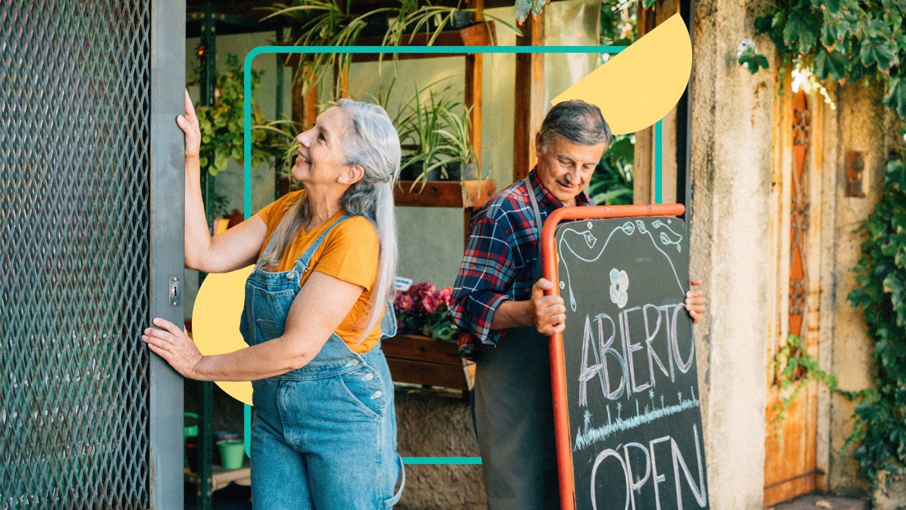 A man holding a large open sign and a woman pushing open a gate work to open their business for the day.